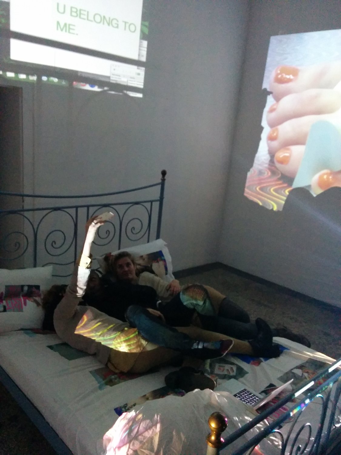 Exploit & Disappear — visitors on the ornate iron bed under the projections
