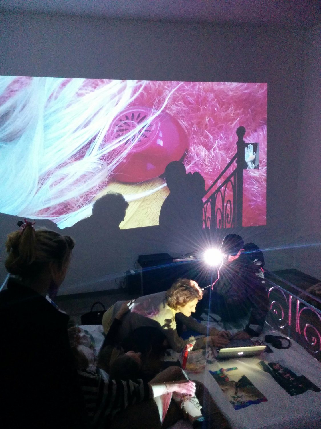 Exploit & Disappear — performer reclining with a laptop, visitors watching