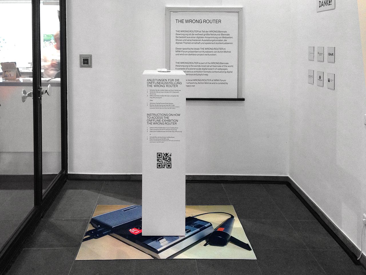 The Wrong Router — the router on a pedestal in the museum, 'THE WRONG ROUTER' wall text
